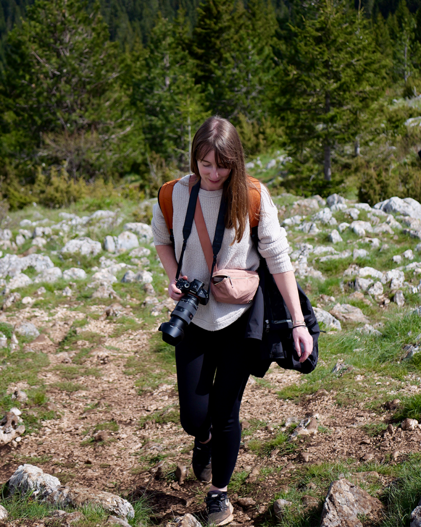 Hannah holding a camera whilst on a hike in Northern Montenegro.